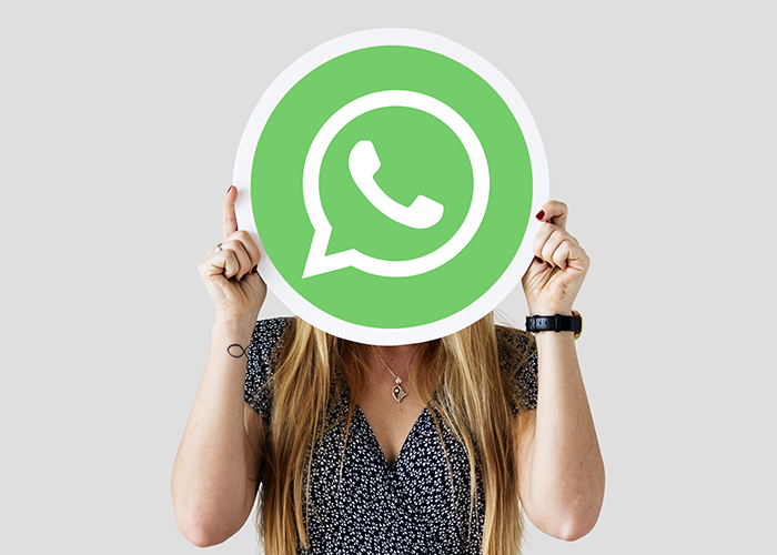 Mulher segurando um logo do WhatsApp